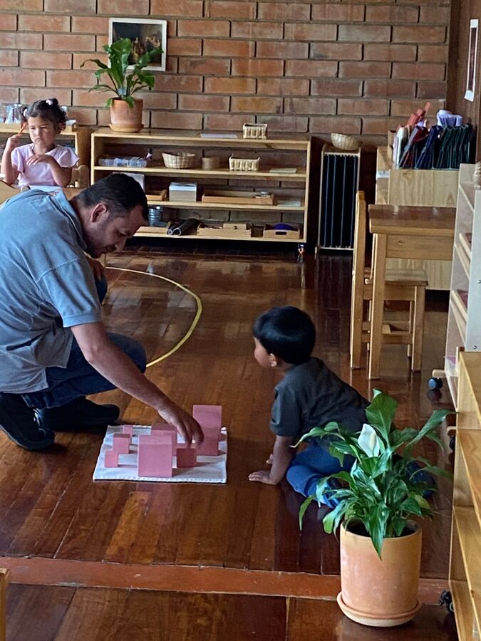 Guía presentando la torre rosa a un niño en Casa de Niños