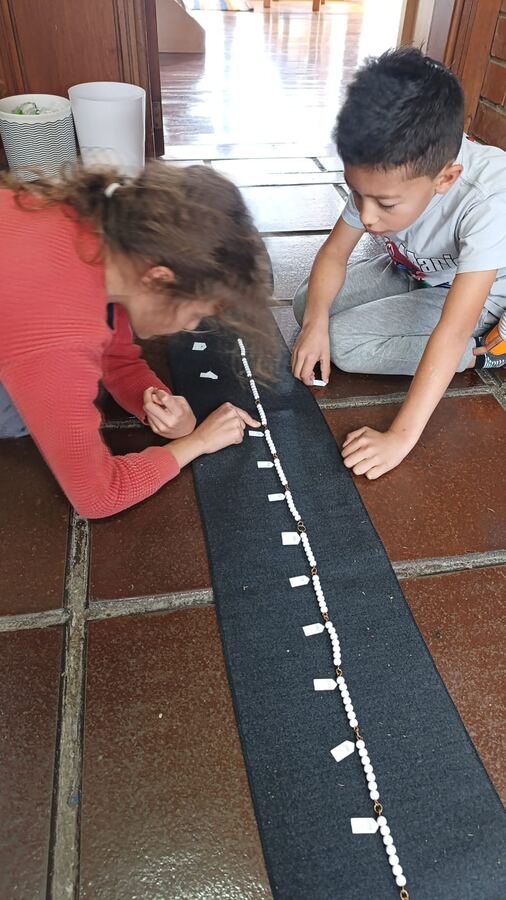 Dos niños contando con la cadena de cuentas