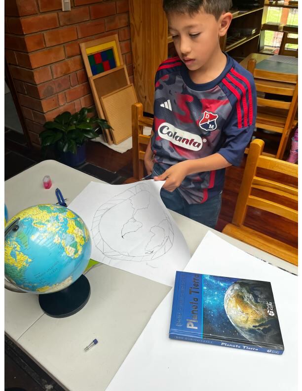 Niño de Taller trabajando las líneas de latitud y longitud con el globo terráqueo