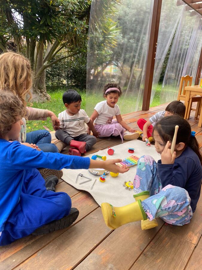 Niños cantando y aprendiendo inglés con instrumentos en la terraza