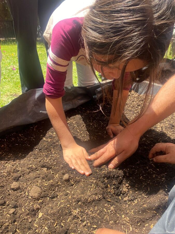Niña preparando la tierra de la huerta